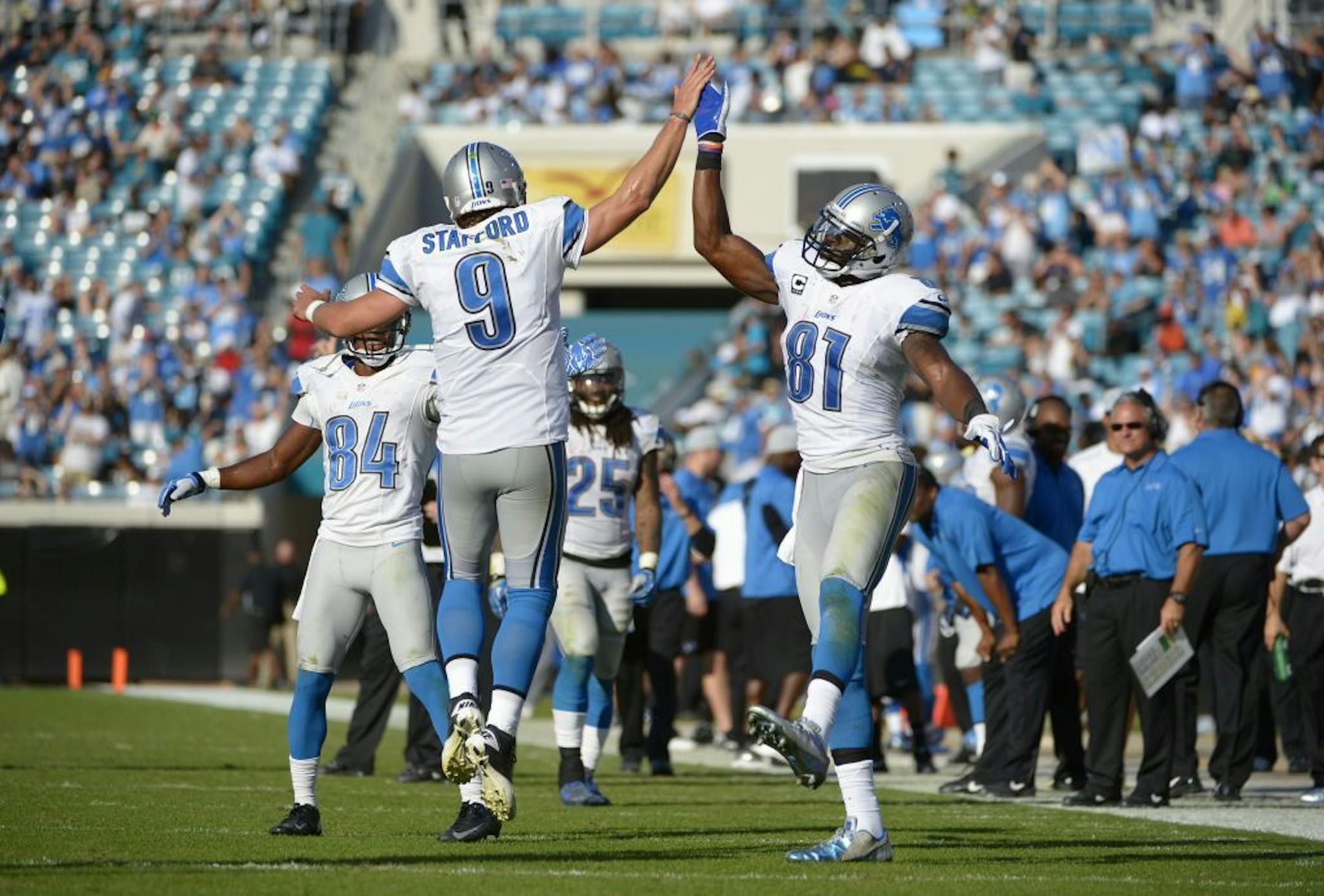 Detroit Lions quarterback Matthew Stafford (9) and wide receiver Calvin Johnson (81) celebrate after a touchdown by running back Joique Bell during the second half of an NFL football game against the Jacksonville Jaguars in Jacksonville, Fla., Sunday, Nov. 4, 2012. The Lions won 31-14.