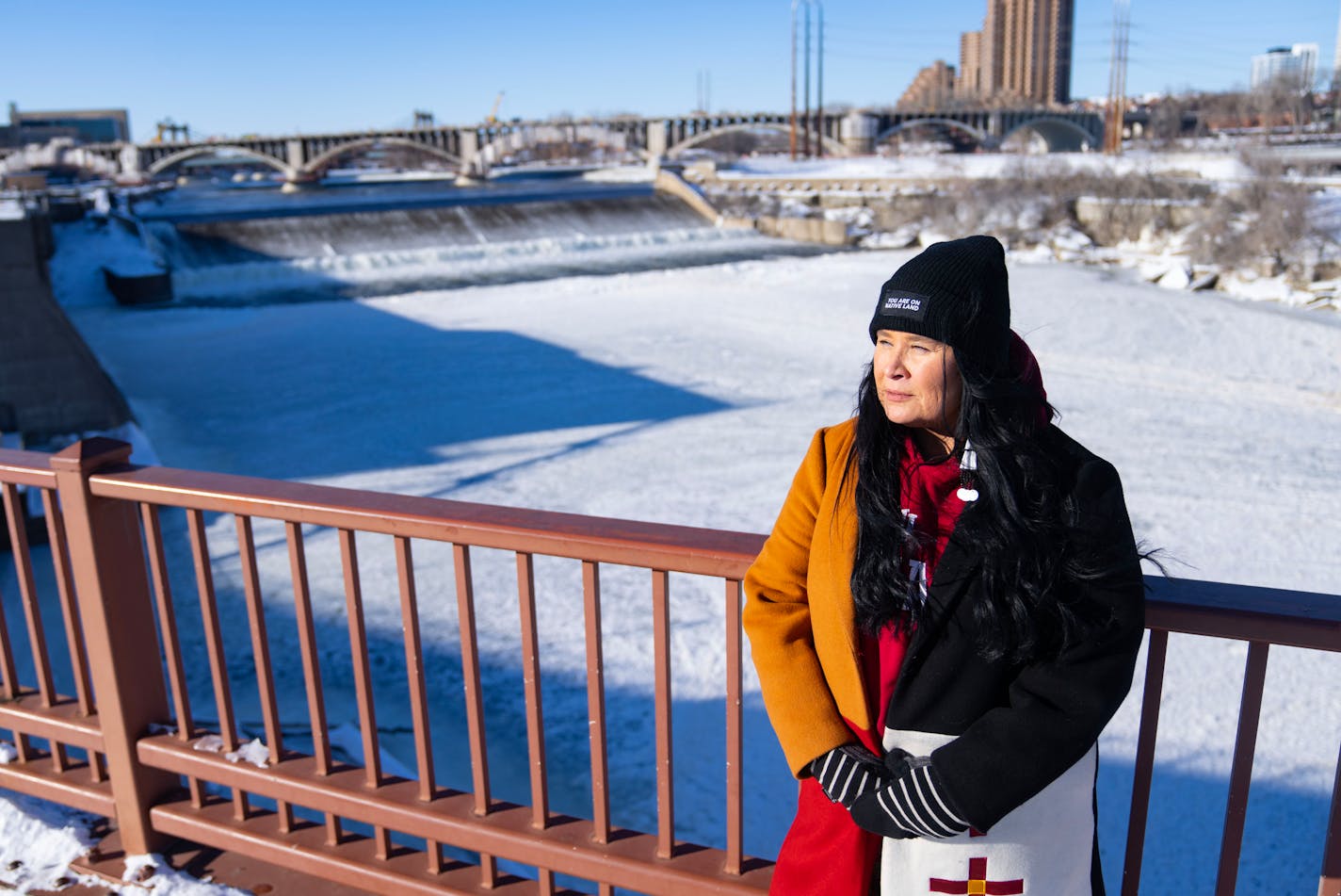 Shelley Buck, president of Friends of the Falls and a member of the Dakota Nation, poses for a portrait Thursday, Feb. 2, 2023 on the Stone Arch Bridge overlooking the Mississippi River and St. Anthony Falls in Minneapolis.    ]