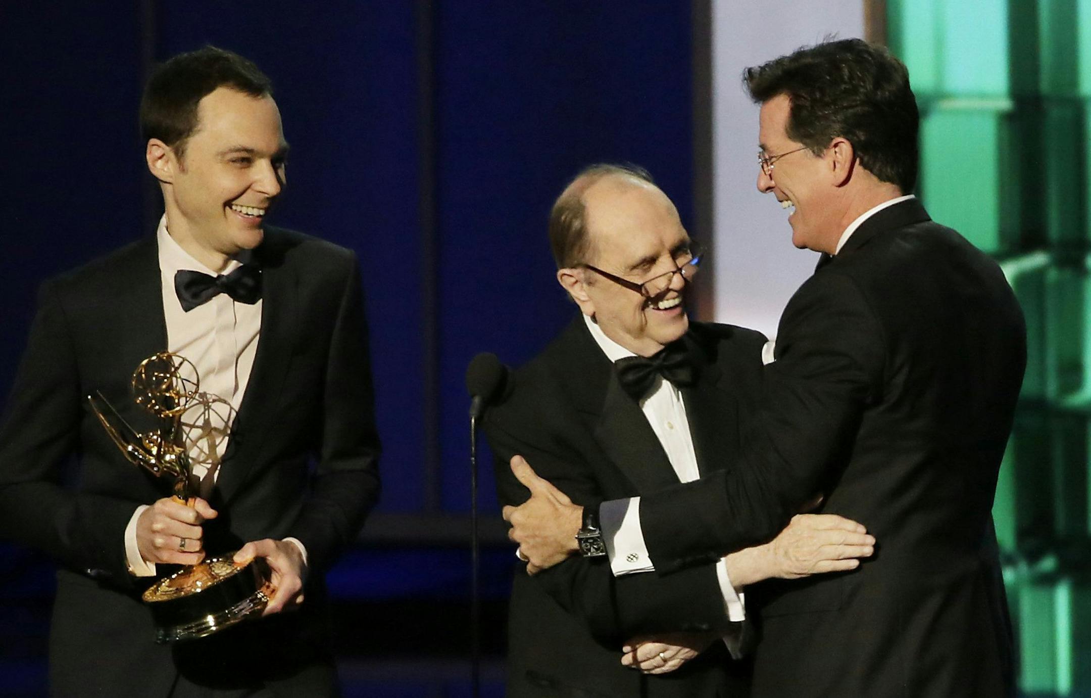 Stephen Colbert, right, accepts an award from Bob Newhart and Jim Parsons, left, at the 65th Annual Primetime Emmy Awards on Sunday, September 22, 2013, at Nokia Theatre, L.A. Live, in Los Angeles, California. (Robert Gauthier/Los Angeles Times/MCT) ORG XMIT: 1143552