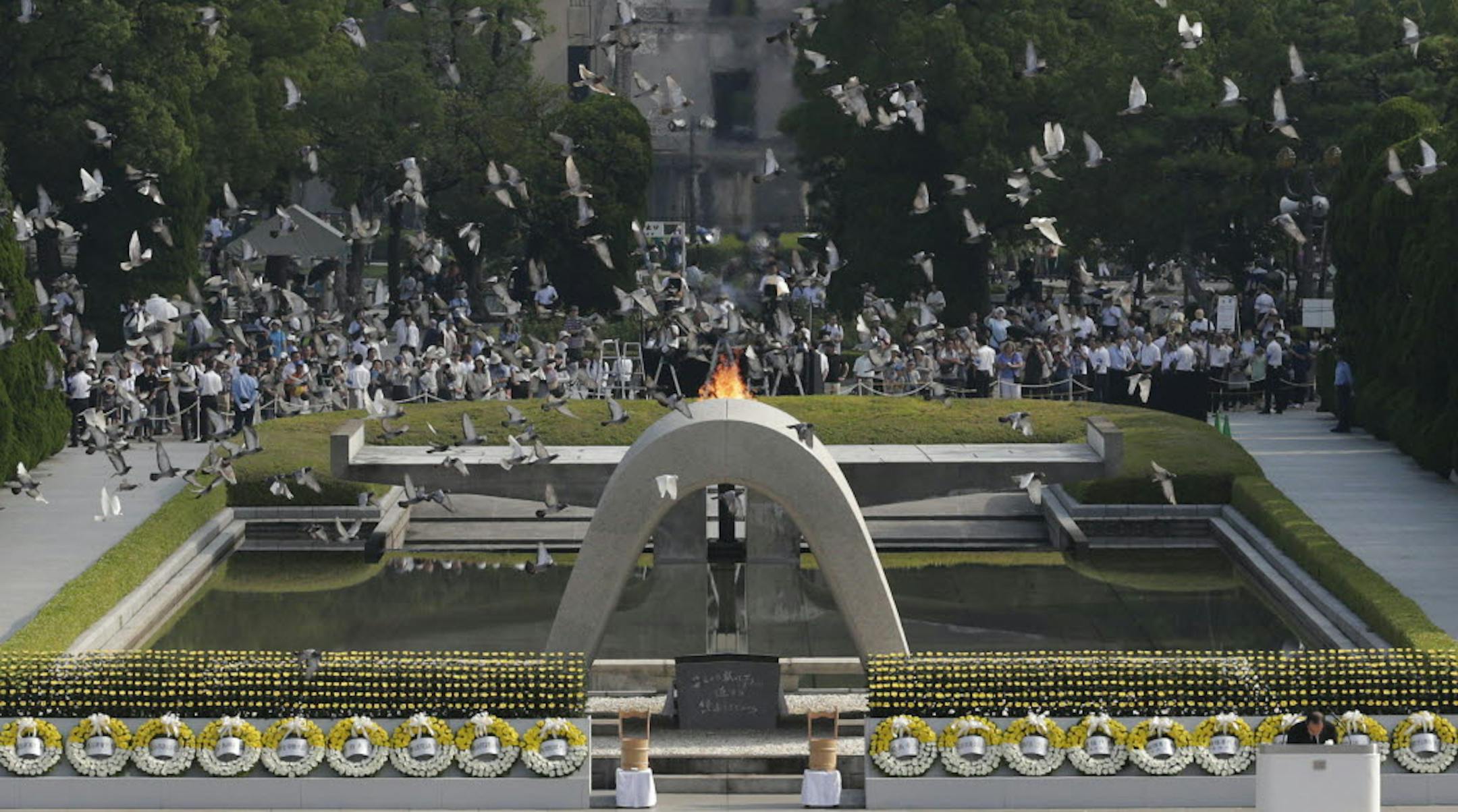 Doves fly over the cenotaph dedicated to the victims of the atomic bombing at the Hiroshima Peace Memorial Park during the ceremony to mark the 68th anniversary of the bombing, in Hiroshima, Tuesday, Aug. 6, 2013.