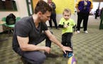 Minnesota Vikings kicker Blair Walsh held a football for Max Birdwell (4) during a visit at Northpoint Elementary School Thursday.