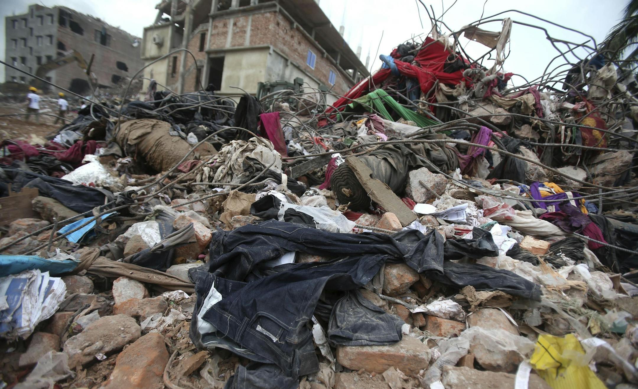 Pairs of brand new denim jeans are strewn over rubble from the collapsed garment factory building, Saturday, May 4, 2013 in Savar, near Dhaka, Bangladesh. In the aftermath of last week's building collapse that killed more than 530 people, Bangladesh's garment manufacturers may face a choice of reform or perish. Home to five factories that supplied clothing to retailers in Europe and the United States, the shoddily constructed building's collapse has put a focus on the high human price paid when