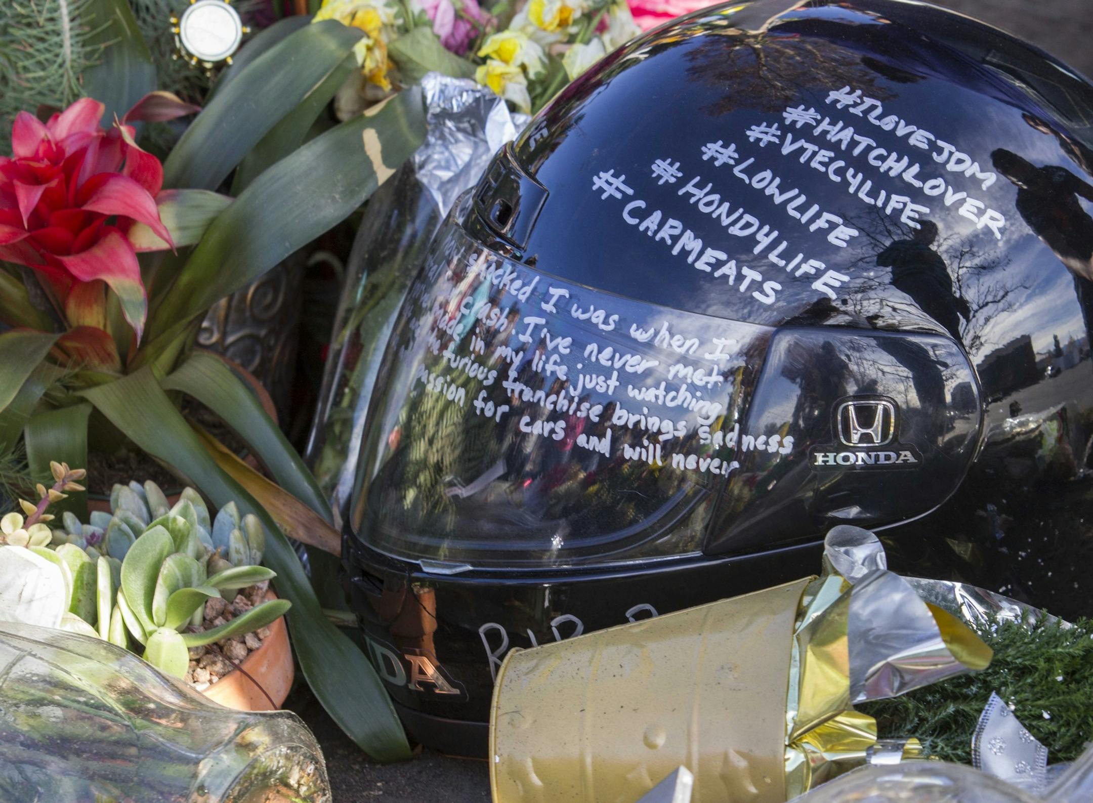 Messages on a helmet is placed at a memorial rally and car cruise in Valencia, Calif., Sunday, Dec. 8, 2013 to remember actor Paul Walker and his friend Roger Rodas, who died in a fiery car crash last Saturday. (AP Photo/Ringo H.W. Chiu)