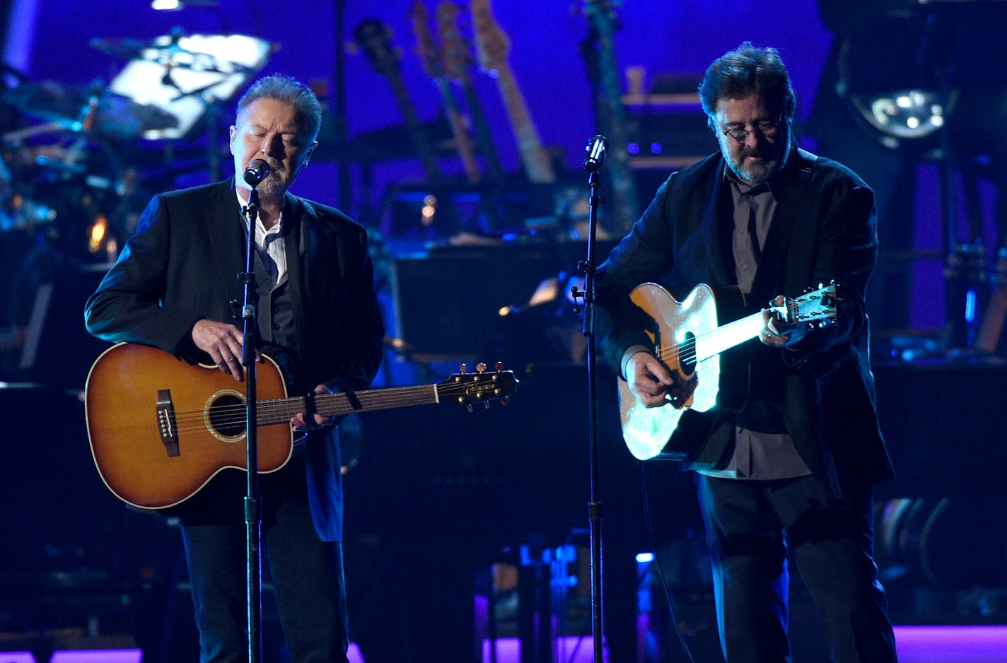 FILE - This Feb. 8, 2019 file photo shows Don Henley, left, and Vince Gill performing "Eagle When She Flies" at MusiCares Person of the Year honoring Dolly Parton in Los Angeles. Eagles, with Deacon Frey and Vince Gill, are planning massive performances of their album "Hotel California" during their 2020 tour. Performances of the band's 1976 album will include a 46-piece orchestra and a 22-voice choir. Organizers announced Tuesday that in total, 77 musicians are expected to be onstage while Eagles perform hits from the album including "New Kid in Town" and "Life in the Fast Lane." (Photo by Chris Pizzello/Invision/AP, File)