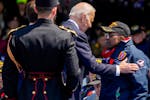 President Joe Biden greets World War II veteran Richard Stewart after he was awarded in the Legion of Honor by French President Emmanuel Macron during