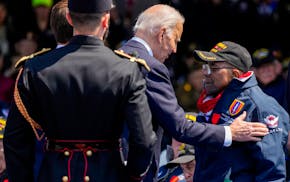 President Joe Biden greets World War II veteran Richard Stewart after he was awarded in the Legion of Honor by French President Emmanuel Macron during