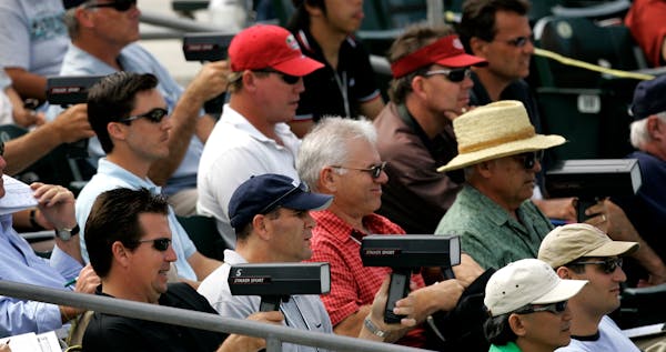 In this 2007 file photo, baseball scouts used radar guns to read the speed of a pitch during a spring training baseball game between the Florida Marli