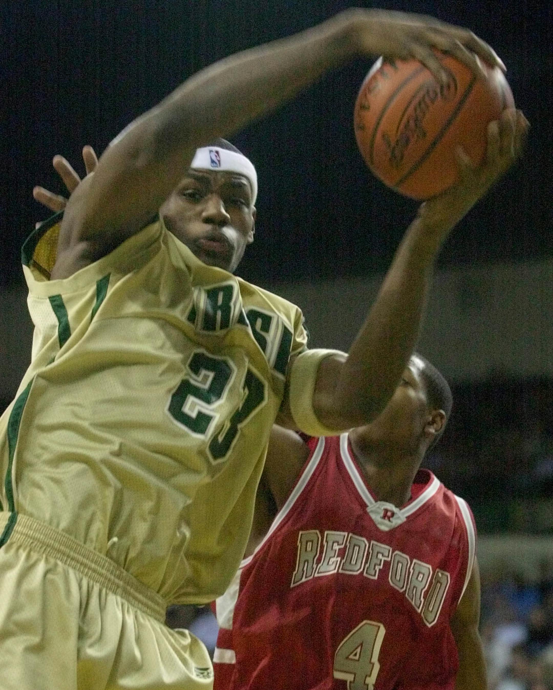 High school phenom LeBron James (23) of Akron St. Vincent-St. Mary pulls down a rebound in front of Detroit Redford's Ronnie Cranford Sunday, Jan. 12, 2003, in Cleveland. (AP Photo/Mark Duncan) ORG XMIT: MIN2013051318541282