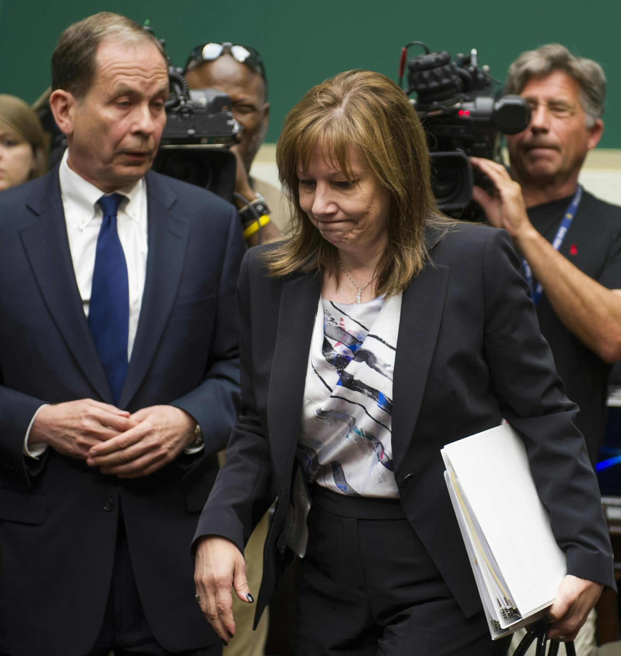 General Motors CEO Mary Barra walks past former US Attorney Anton Valukas, investigator , Jenner & Block, left, and television cameras as she arrives on Capitol Hill in Washington, Wednesday, June 18, 2014, to testify before the House Oversight and Investigations subcommittee hearing examining the facts and circumstances that contributed to General Motors’ failure to identify a safety defect in certain ignition switches and initiate a recall in a timely manner. (AP Photo/Cliff Owen)