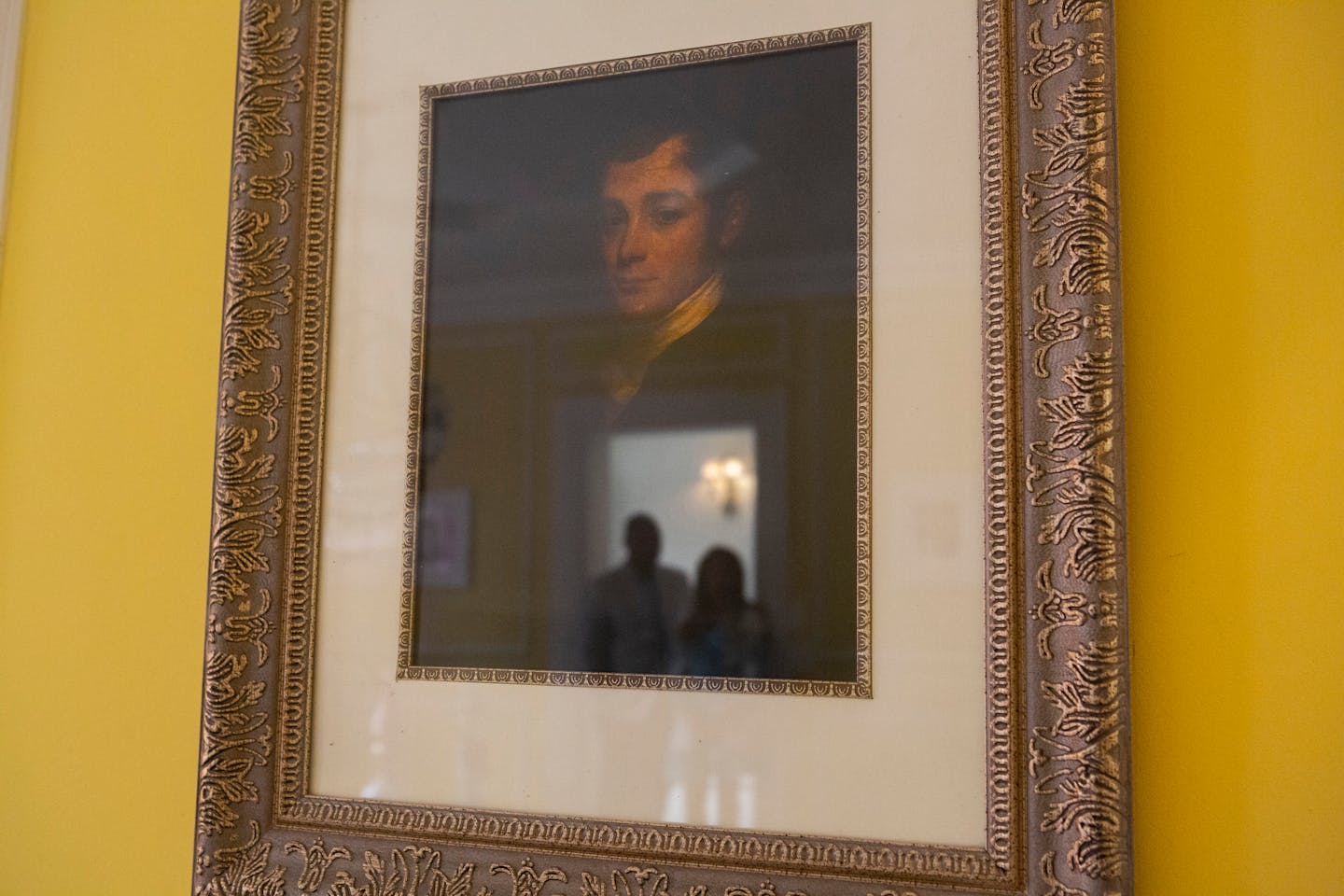 Jamie and Frantz Arty are reflected in a portrait of the original homeowner, William Townsend McCoun, a prominent New York abolitionist and judge, who lived in the mansion until his death in 1878. in Photographed July 9, 2021, in Oyster Bay, N.Y. MUST CREDIT: Photo for The Washington Post by Calla Kessler