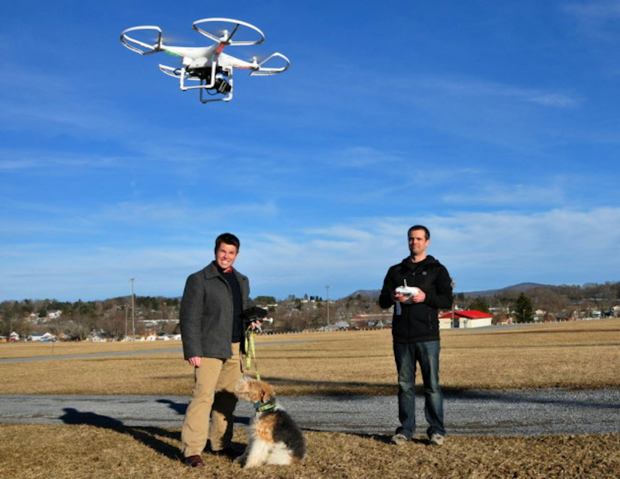 In this photo taken on Friday, March 7, 2014 and provided by Foxfire Realty, Jonathan Collins, right, and Paul Grist, test-fly Foxfire Realtyâs new camera-equipped drone at the West Virginia State Fairgrounds in Lewisburg, W.Va. The drone, named Chopper Foxfire, carries a high-resolution Go-Pro camera capable of taking high-definition video and still photos. (AP Photo/Foxfire Realty)