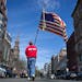 Lt. Mike Murphy of the Newton, Mass., fire dept., carries an American flag down the middle of Boylston Street after observing a moment of silence in h