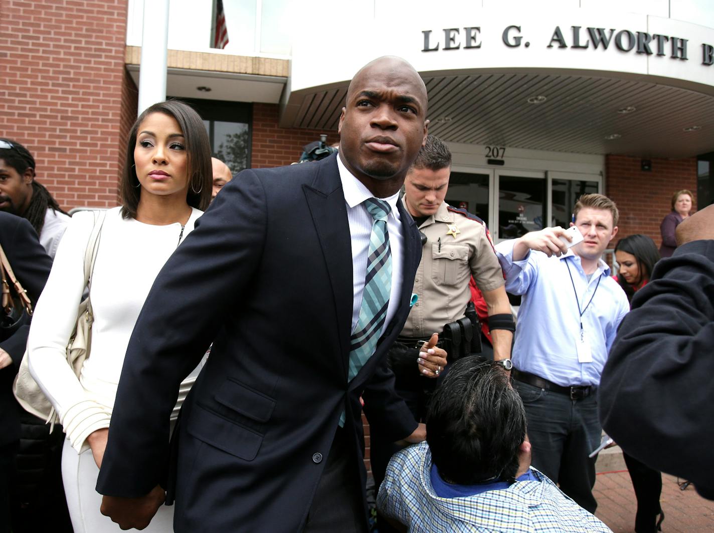 Minnesota Vikings running back Adrian Peterson leaves the courthouse with his wife Ashley Brown Peterson Tuesday, Nov. 4, 2014, in Conroe, Texas. Adrian Peterson avoided jail time on in a plea agreement reached with prosecutors to resolve his child abuse case. (AP Photo/Pat Sullivan) ORG XMIT: TXPS105