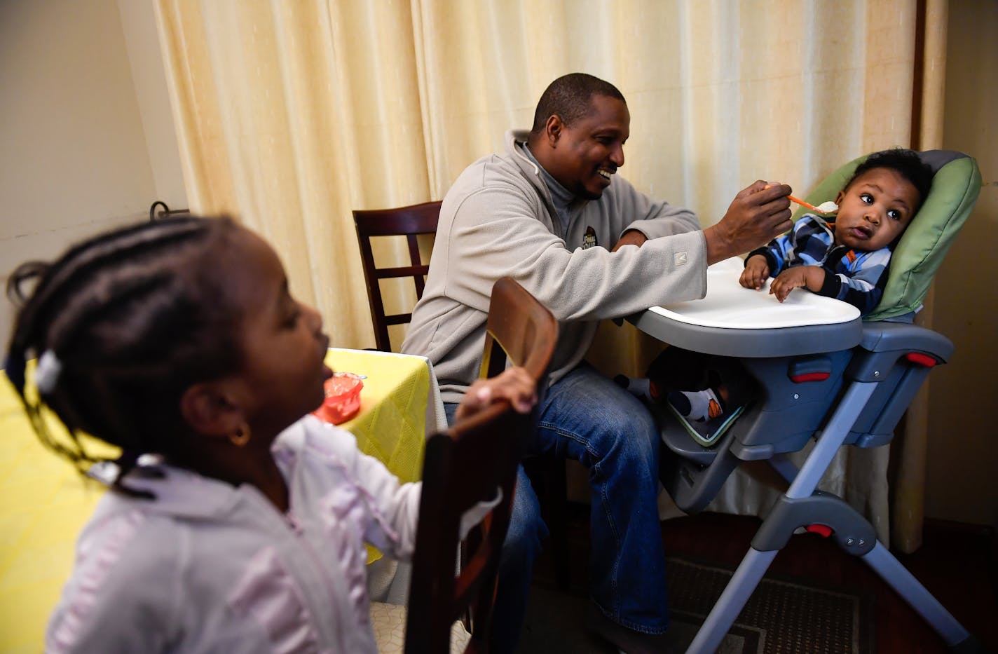 Papa Faal fed his son, 9-month old Cherno Muhamed, as 3-year old Isha watched Tuesday night. ] (AARON LAVINSKY/STAR TRIBUNE) aaron.lavinsky@startribune.com Almost two years ago, Papa Faal ,a quiet family man, Army vet and IT instructor from Brooklyn Park, traveled to Gambia and took part in armed plot to overthrow the West African nation's ruler of more than two decades. After the coup failed, the U.S. government convicted Faal of taking up arms against a friendly country but gave him a light se