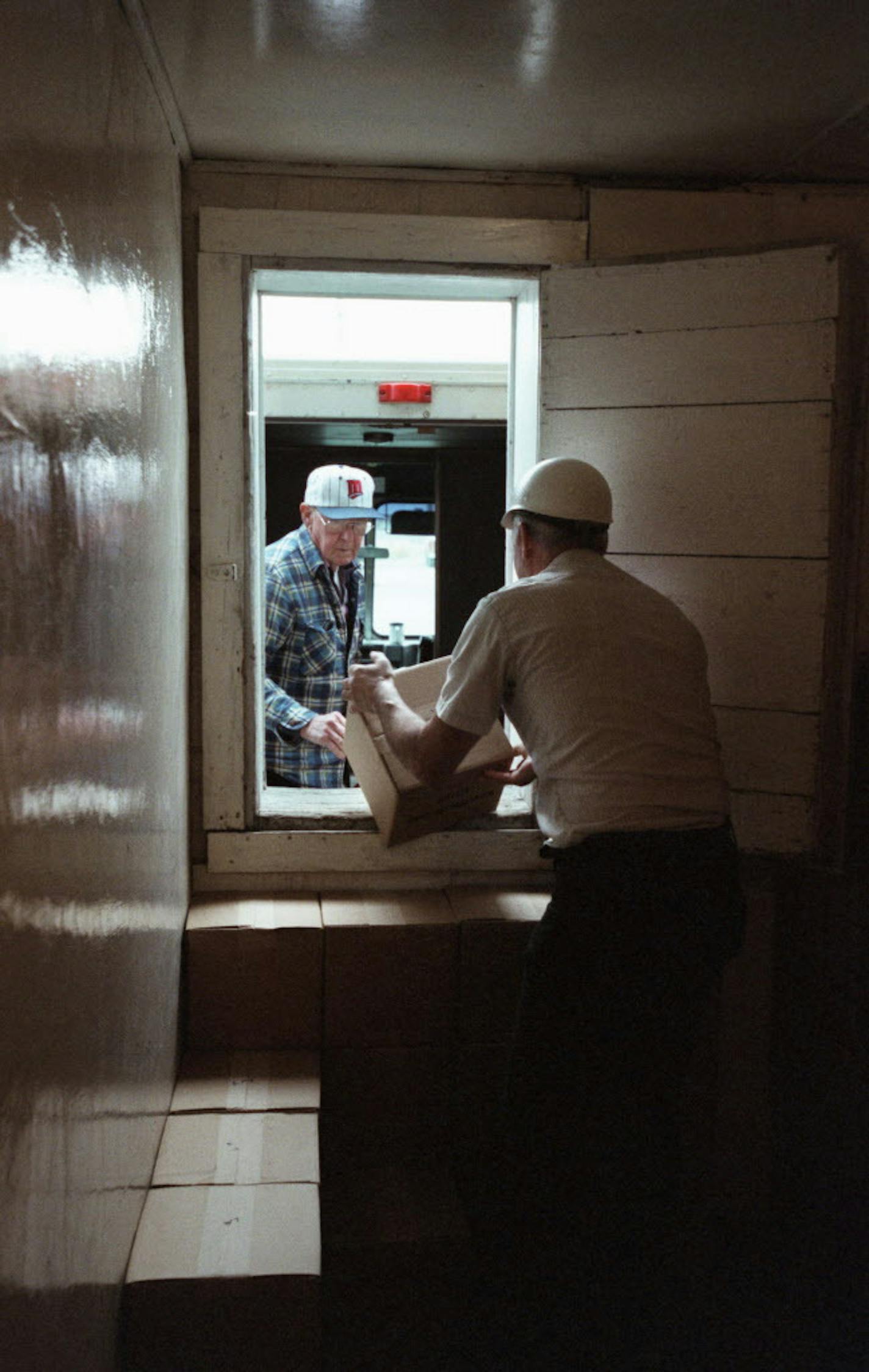 Making butter the old-fashioned way ... Hope Creamery is one of the last of it&#xcc;s kind ... possible milenium story ... -- (THIS PHOTO_Monday,04/10/00_Hope,Mn.) - - - Gene Kruckeberg hands cases of butter out a passage in the cold room to Duane Hanson, who was picking up a load of butter for the Lake Mills Coop Creamery in Iowa. The Lake Mills coop no longer makes their own butter, but buys it from the Hope Creamery for sale to local stores in Iowa.