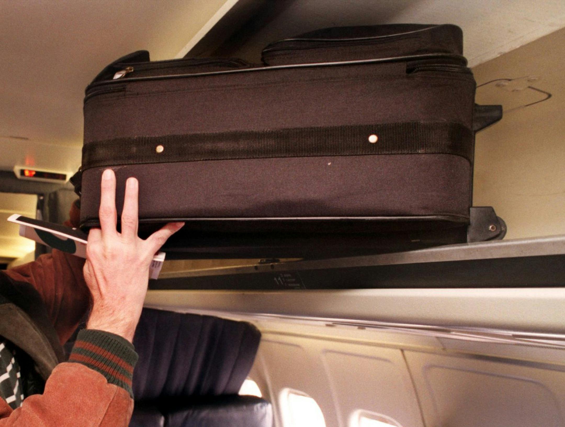 KRT BUSINESS STORY SLUGGED: CARRYON KRT PHOTO BY LEW STAMP/AKRON BEACON JOURNAL (KRT123 - December 22) Brent Byerley stows his carry on luggage in the overhead compartment of an Air Tran flight. Travelers are having to face changes in carry on restrictions as planes become more crowded and airlines enforce rules that can vary from airline to airline. (AK) PL KD 1998 (Horiz) -- NO MAGS, NO SALES -- ORG XMIT: KRT123 ORG XMIT: MIN2014030415531274