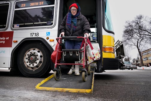 Joy Rindels-Hayden, 87, waged a prolonged campaign to pass a state law to improve bus safety during the dangerous winter months after she suffered a near-debilitating brain injury years ago while getting off a metro bus and was seen getting off a bus near a Southside food pantry Friday, Jan. 13, 2023 in Minneapolis, Minn. ]