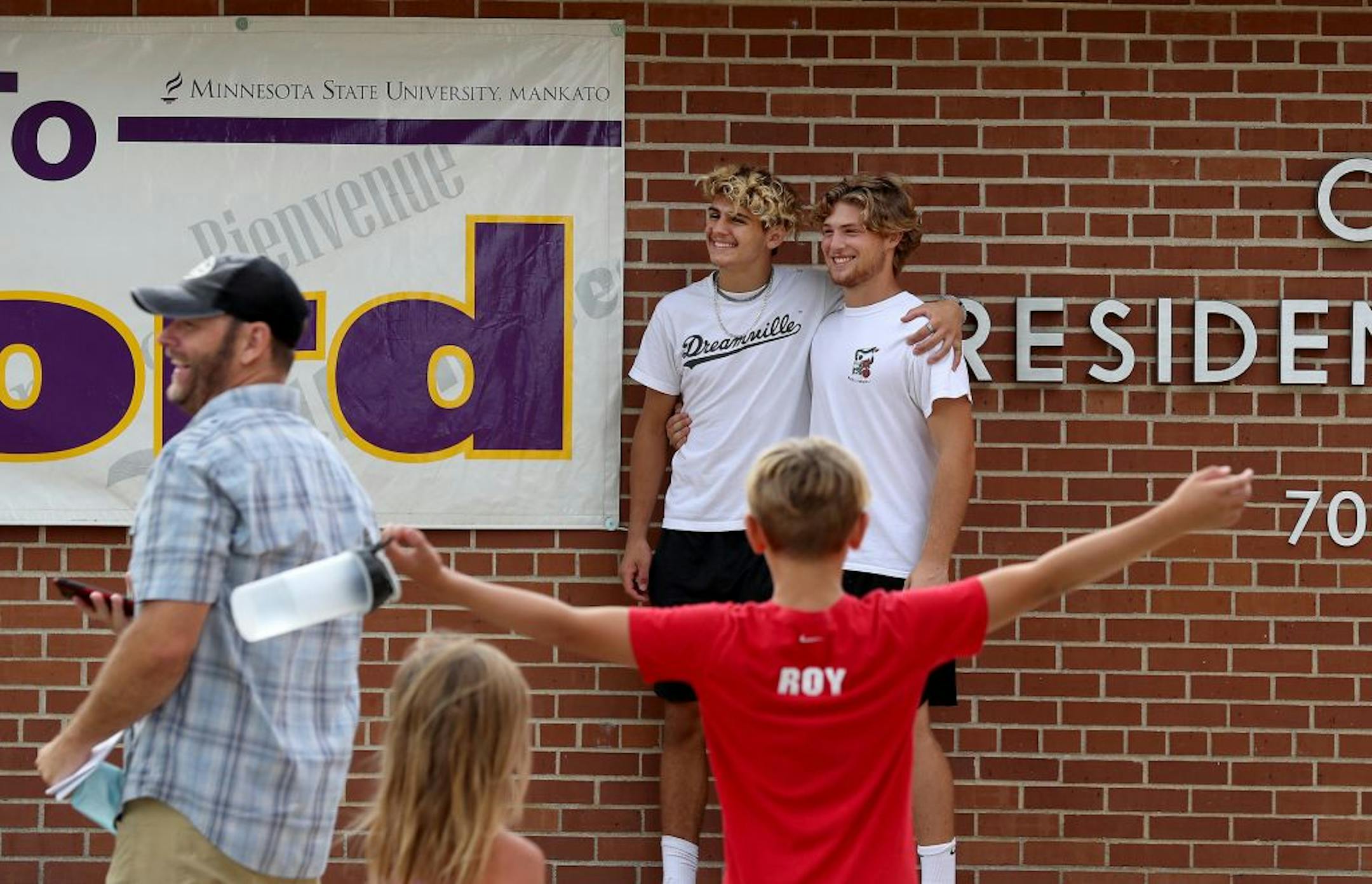 Students began moving into dormitories at Minnesota State University-Mankato Thursday where high school friends from Lakeville , rear right to left, and Gavin Roy, both new freshman at Minnesota State, celebrated their new status while posing for photos for family members.
