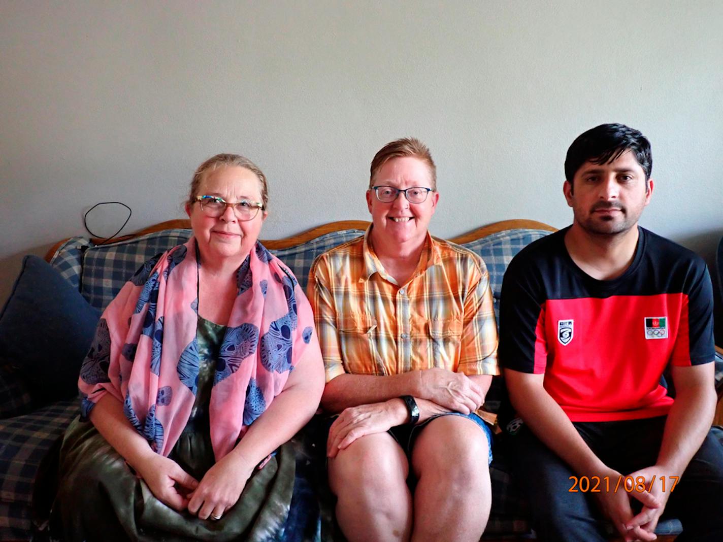 In this photo provided by Caroline Clarin, is Sheril Raymond, from left, Clarin and Ihsanullah Patan sitting together in an apartment on Tuesday, Aug. 17, 2021, in Fergus Falls, Minn. Raymond and Clarin, who worked for a U.S. Department of Agriculture in Afghanistan, helped Patan and his family arrive to the United States and get settled in Minnesota. They are part of a number of Americans trying to help Afghans fleeing their country. (Caroline Clarin via AP)