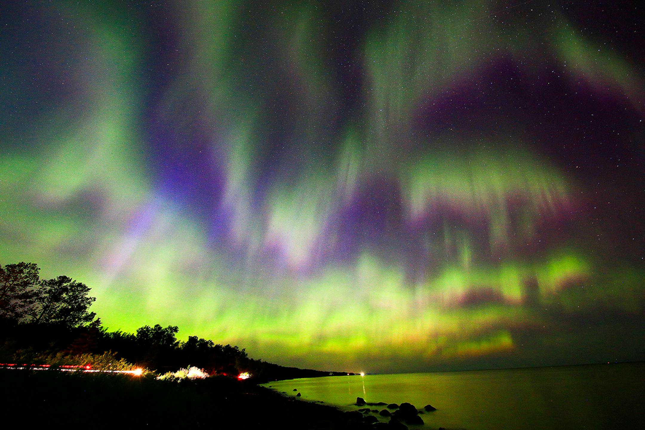 Aurora borealis fills the night sky over Lake Superior at Brighton Beach in Duluth early Tuesday morning. Multiple coronal mass ejections from the sun combined to create a G4-class geomagnetic storm creating the strong auroral display.