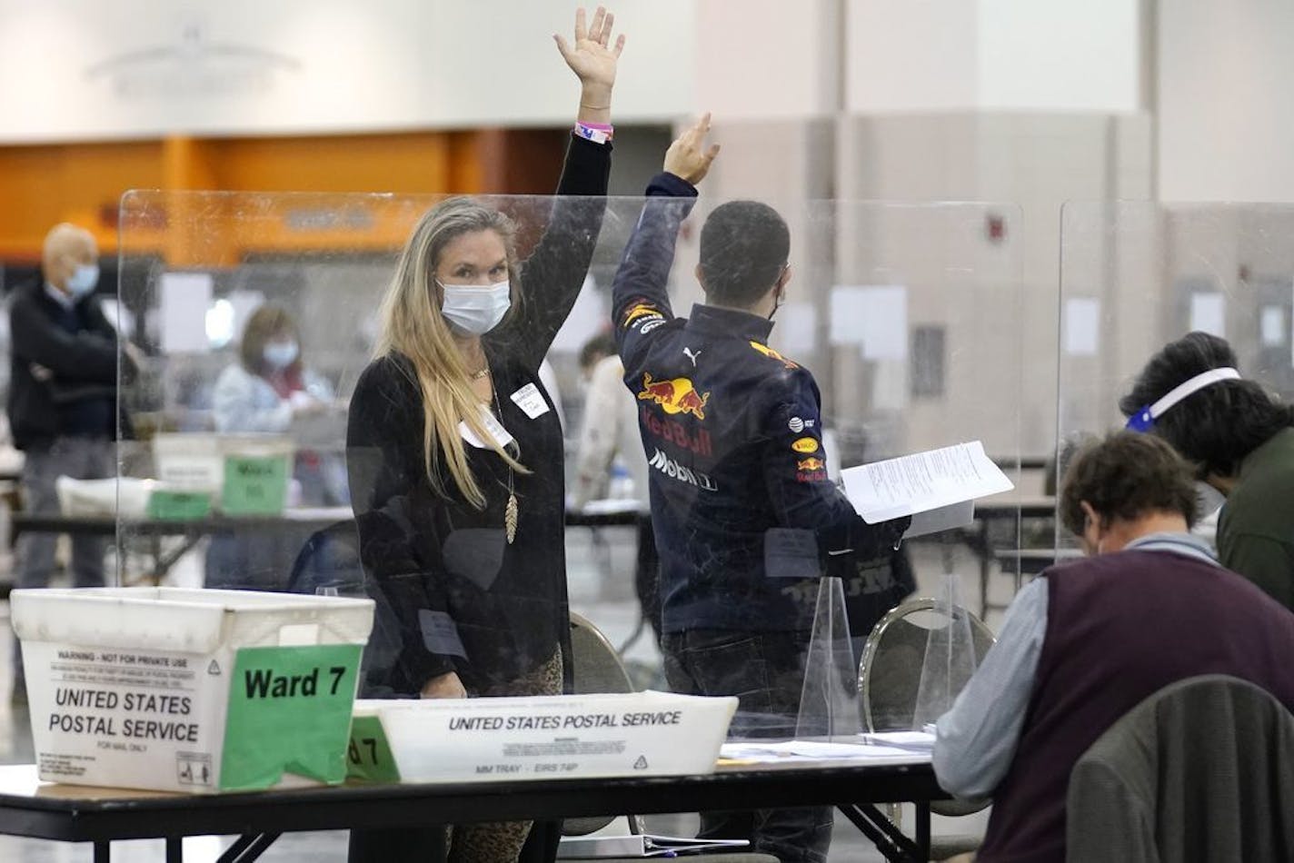 Recount observers raise hands during a hand recount of presidential votes at the Wisconsin Center, Friday, Nov. 20, 2020, in Milwaukee.