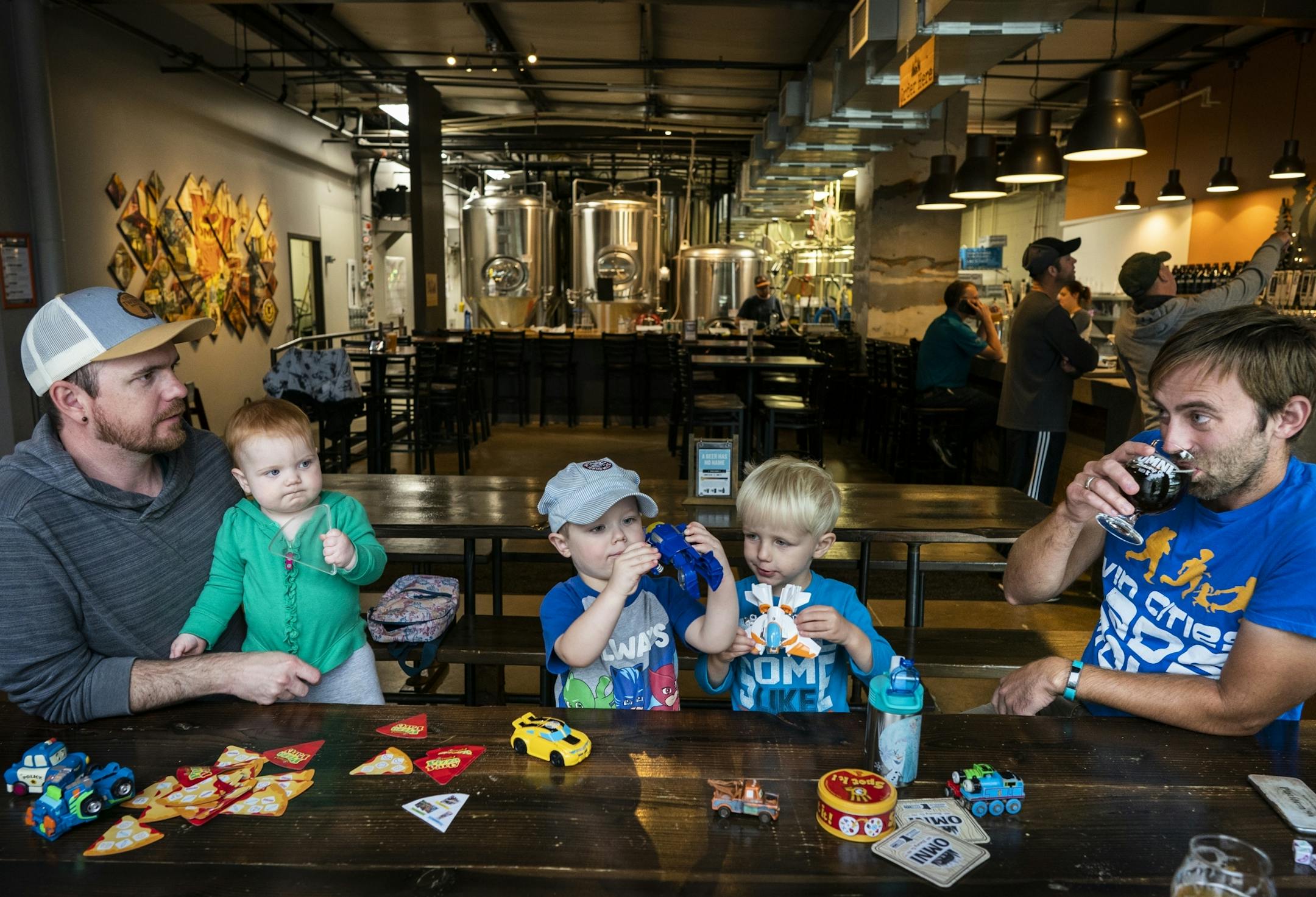 Nic Sabatke, left, with his daughter Mae, 1, and son Anders, 3, attends a Twin Cities Dads playgroup at Omni Brewing in Maple Grove with Keith Nagel, right, and his son Sawyer, 3.