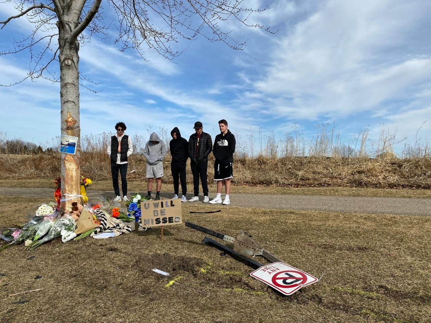 Friends of the victim involved in a fatal crash in Woodbury on Saturday night gathered at the scene of the crash Sunday afternoon where people brought flowers, candles and cards to a growing memorial. Four others were injured in the single-vehicle crash that remains under investigation. (Kim Hyatt/Star Tribune)