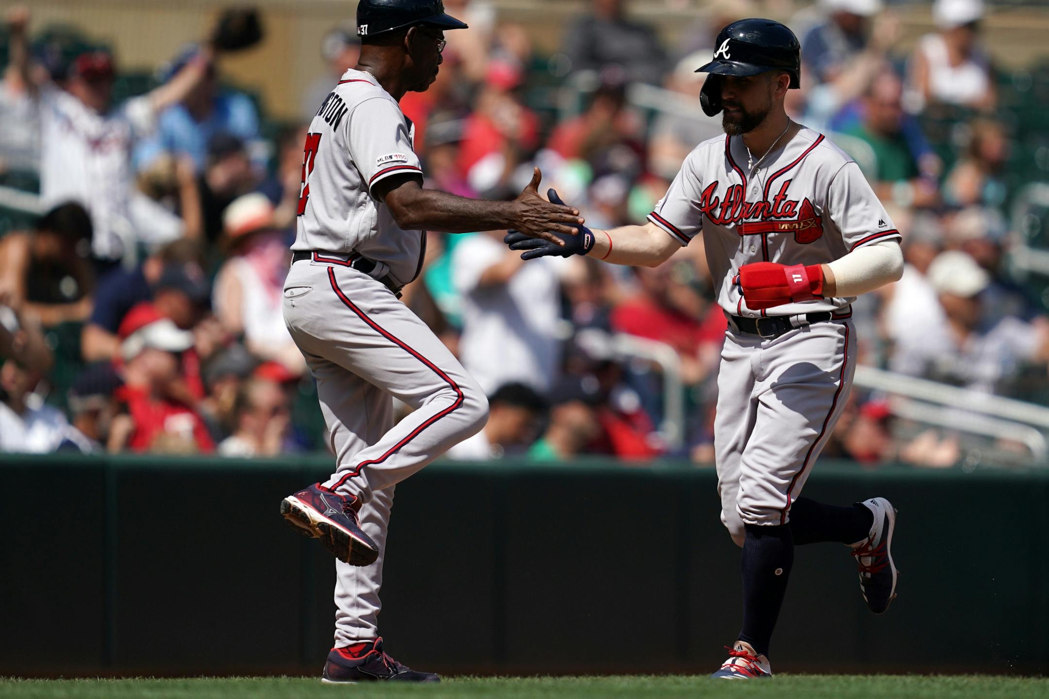 Atlanta Braves center fielder Ender Inciarte (11) celebrated with Atlanta Braves third base coach Ron Washington (37) as he rounded third to score on a ball hit by Atlanta Braves right fielder Ronald Acuna Jr. (13) in the eighth inning.