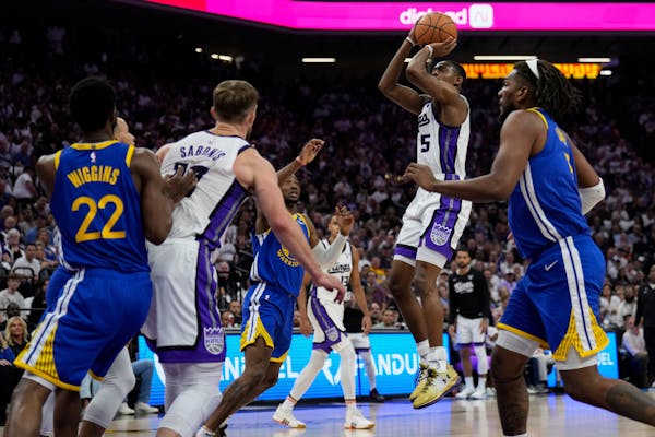 Kings guard De'Aaron Fox (5) shoots during the first half of an NBA play-in tournament game against the Warriors on Tuesday in Sacramento, Calif.