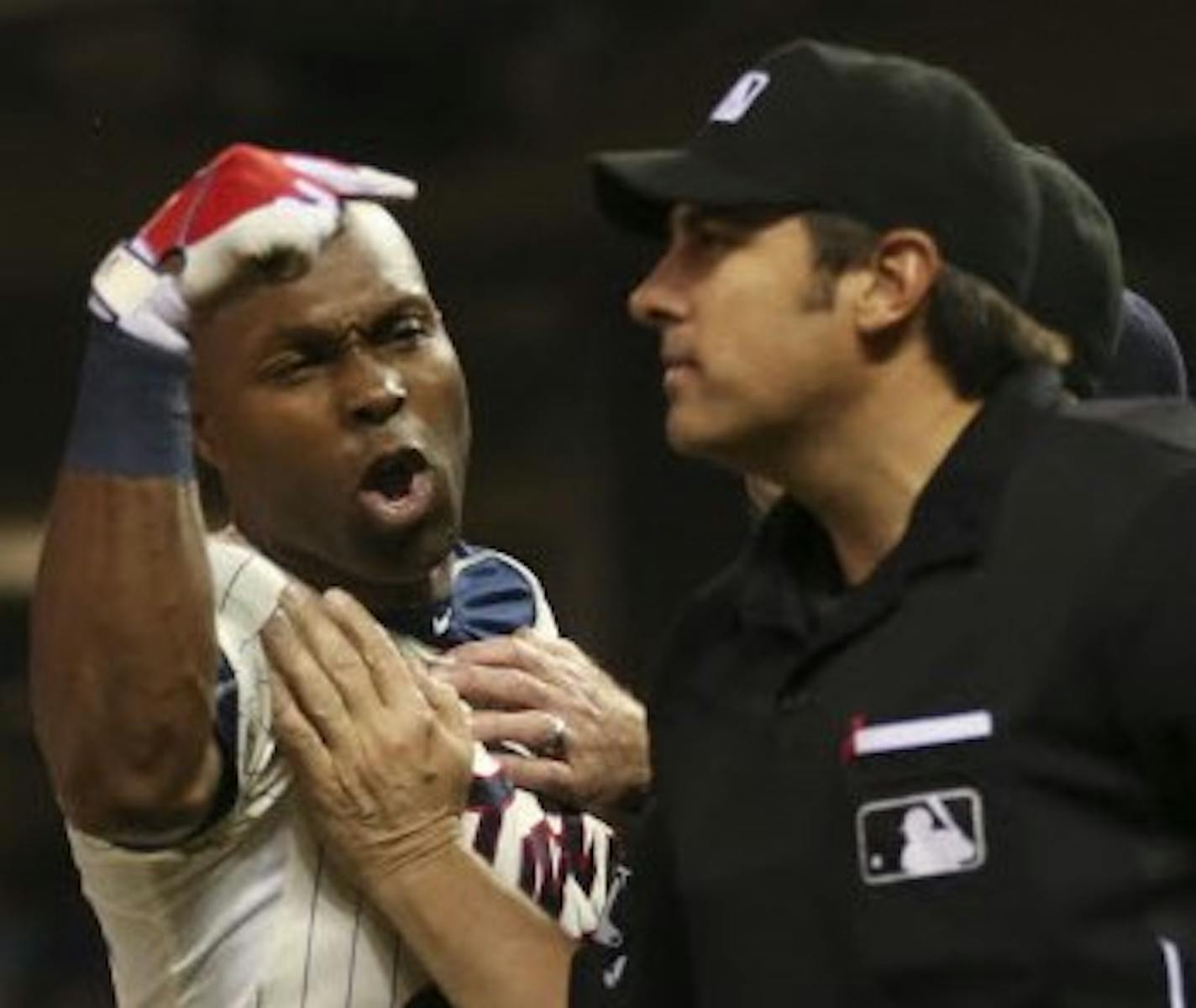 First base umpire Jeff Kellogg, obscured, restrained the Twins' Torii Hunter as he yelled at home plate umpire Mark Ripperger, right, after her ejected Hunter for arguing a called third strike in the eighth inning June 10, 2015. night at Target Field.