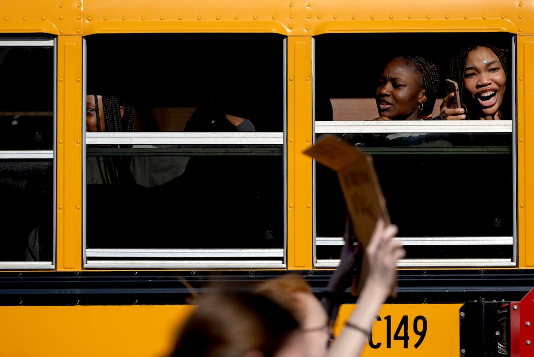 Students on a school bus watch marchers pass by on the street during A Youth for Unity rally and march before an Anoka-Hennepin School Board meeting on Monday in Anoka.