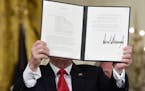 President Donald Trump shows off a "Space Policy Directive" after signing it during a meeting of the National Space Council in the East Room of the Wh