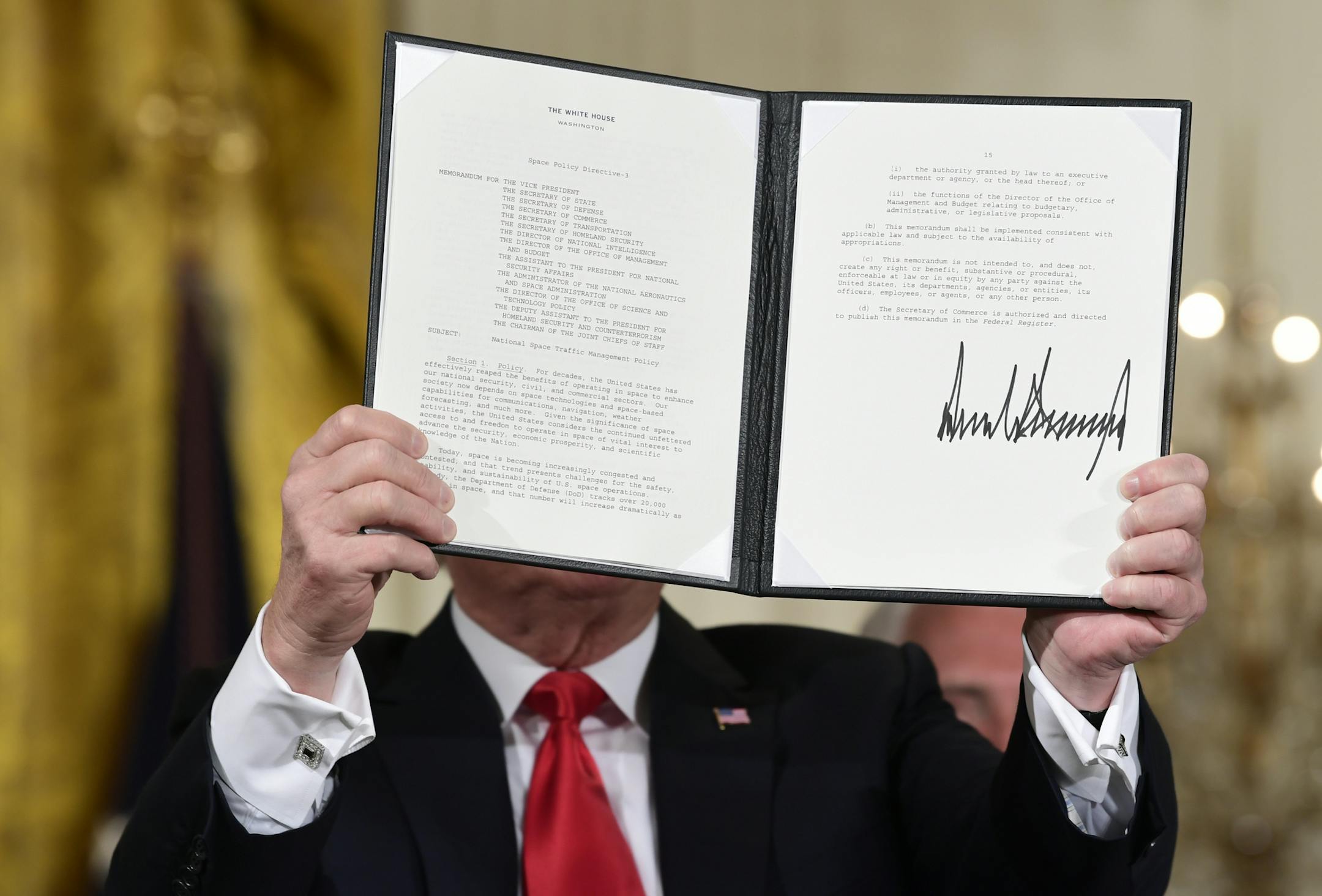 President Donald Trump shows off a "Space Policy Directive" after signing it during a meeting of the National Space Council in the East Room of the White House, Monday, June 18, 2018, in Washington.(AP Photo/Susan Walsh)