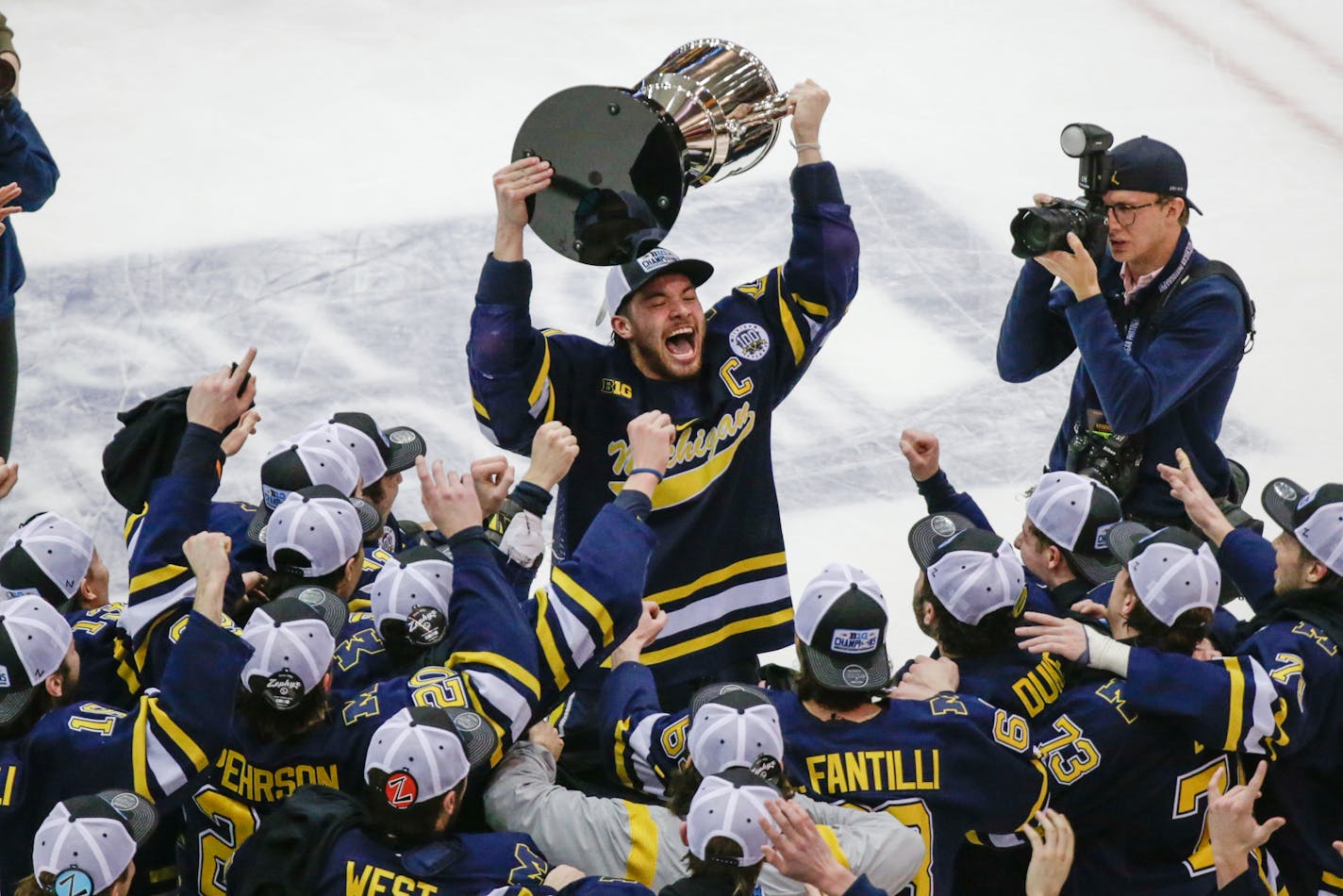 Michigan's Nolan Moyle holds the Big Ten tournament trophy after the team's win over the Gophers on Saturday.