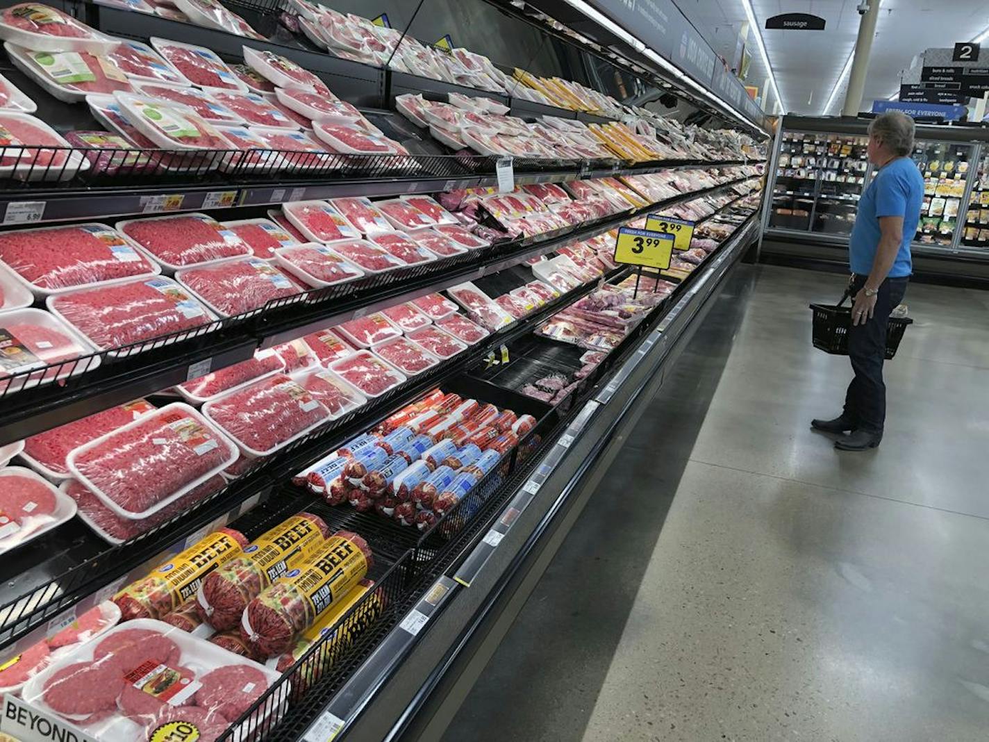 A shopper surveys the overflowing selection of packaged meat in a grocery early Monday, April 27, 2020, in southeast Denver.