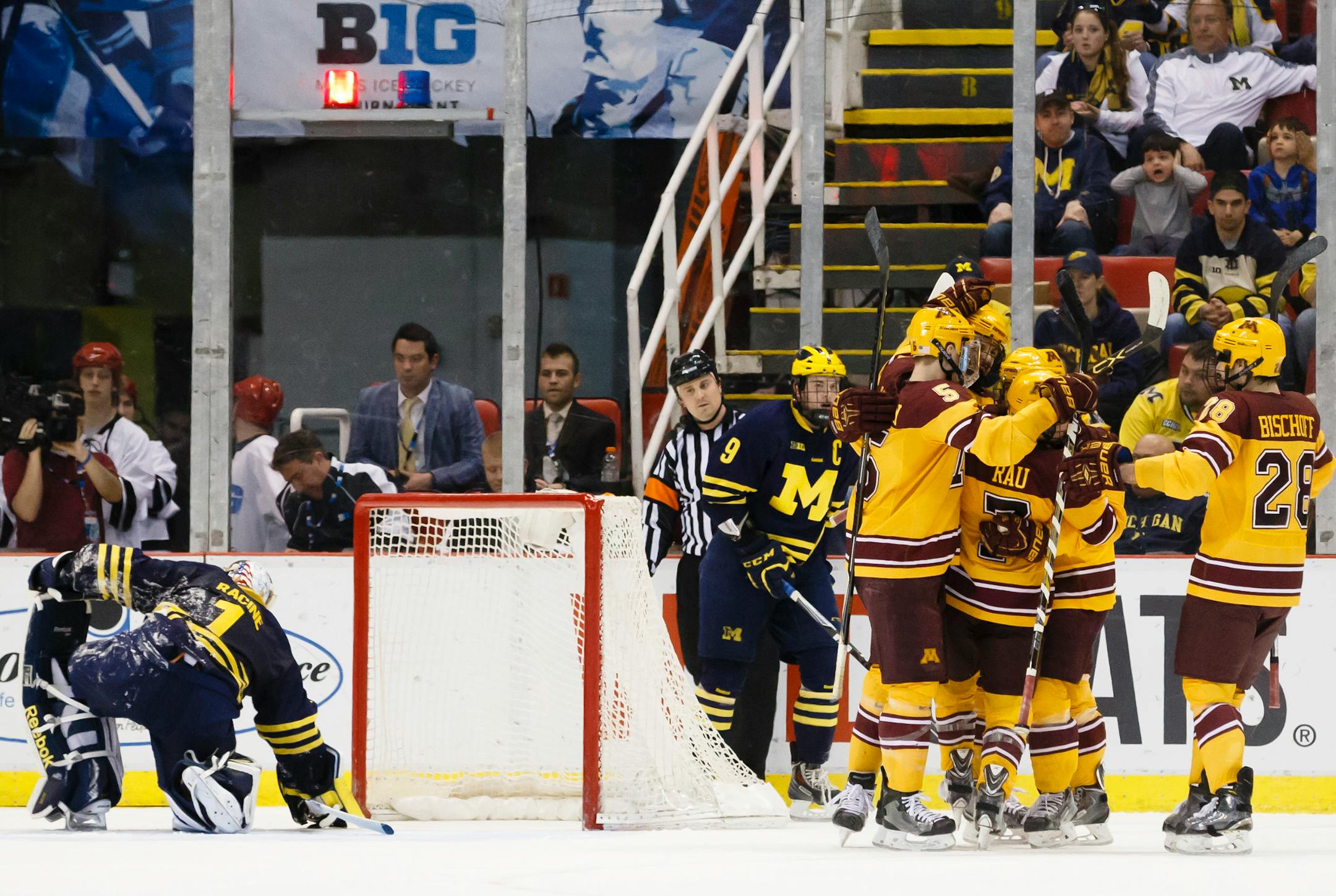 Minnesota's Kyle Rau, center right, celebrates with teammates after scoring against Michigan's Steve Racine, left, in the second period during an NCAA college hockey game in the Big Ten Conference tournament Saturday, March 21, 2015, in Detroit. (AP Photo/Rick Osentoski)