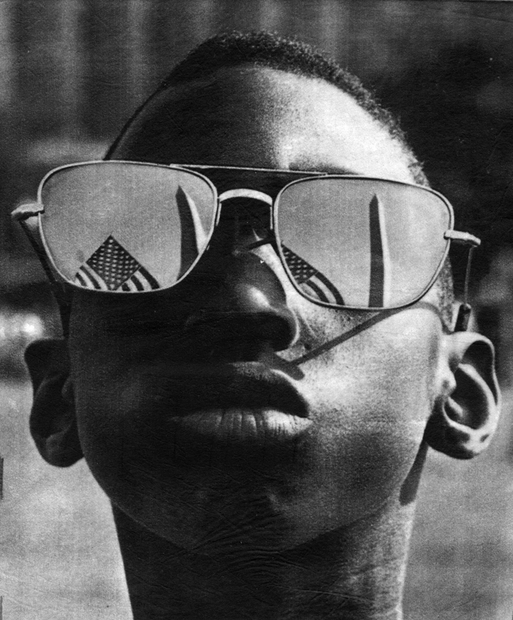 Wednesday August 28, 1963 - Washington DC - Famous civil rights demonstration in Washington DC at which Rev. Martin Luther King Jr. gave his "I Have a Dream" speech. Note US flag and Washington monument reflected in sunglasses. The youth is not identified. Photo is from the wire services, either AP or UPI, ran in the Minneapolis STAR, Thurs Aug 29, 1963, page 1C. ORG XMIT: MIN2012102313240297