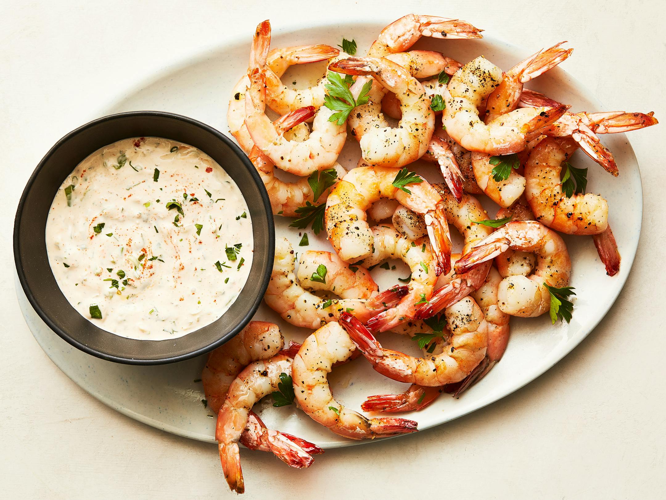 Roasted shrimp cocktail with horseradish sauce in New York, May 9, 2023. Do as Melissa Clark does, and roast, don't poach, the shrimp, then serve them with a creamy horseradish r'moulade. Food styled by Cyd Raftus McDowell. (Armando Rafael/The New York Times)