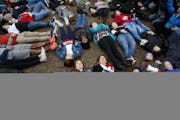 Abby Spangler and her daughter Eleanor Spangler Neuchterlein, 16, hold hands as they participate in a "lie-in" during a protest in favor of gun contro