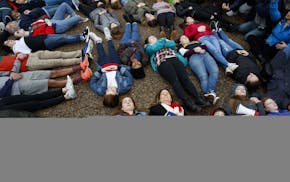 Abby Spangler and her daughter Eleanor Spangler Neuchterlein, 16, hold hands as they participate in a "lie-in" during a protest in favor of gun contro