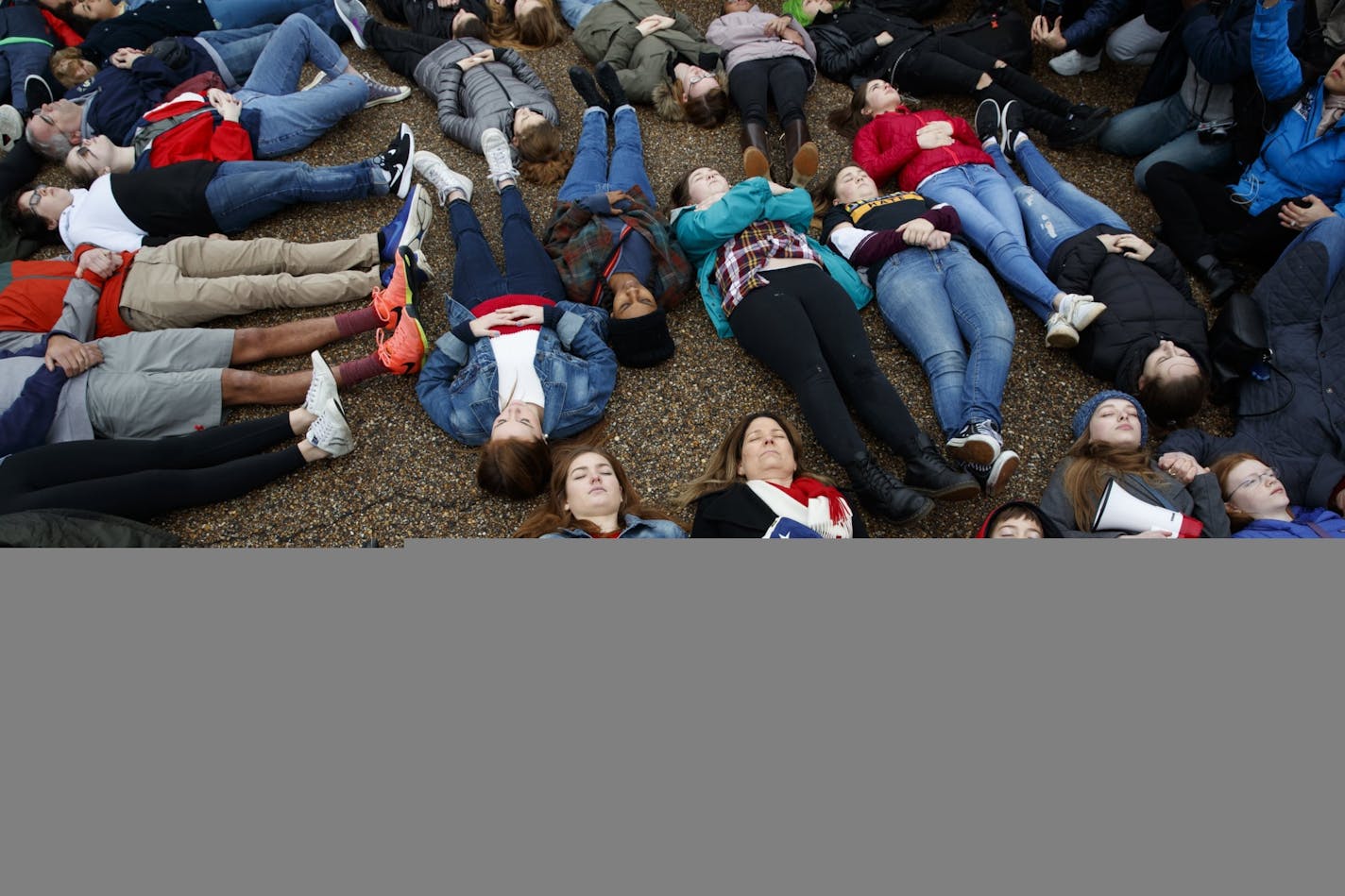 Abby Spangler and her daughter Eleanor Spangler Neuchterlein, 16, hold hands as they participate in a "lie-in" during a protest in favor of gun control reform in front of the White House, Monday, Feb. 19, 2018, in Washington.