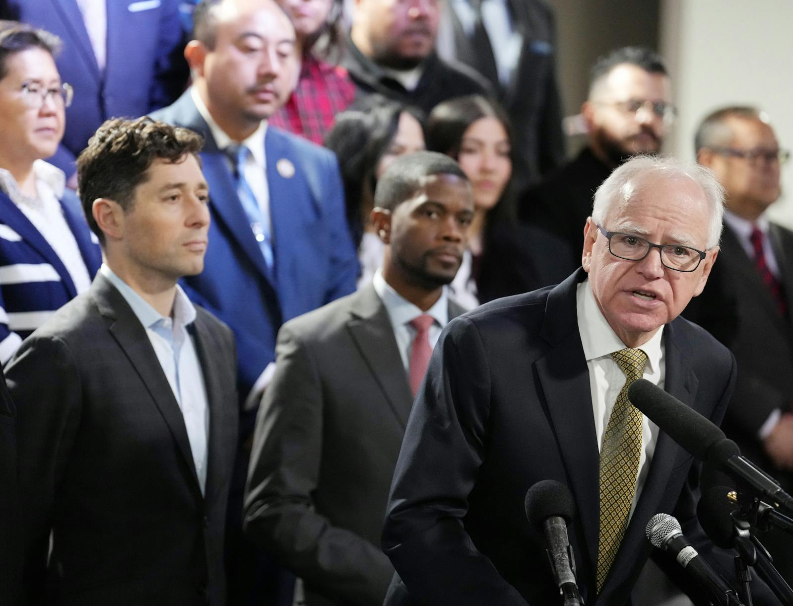 Gov. Tim Walz at a news conference in December with Jacob Frey, Melvin Carter, Kaohly Her and other community members. The Department of Justice subpoenaed the offices of the mayors and governor. 