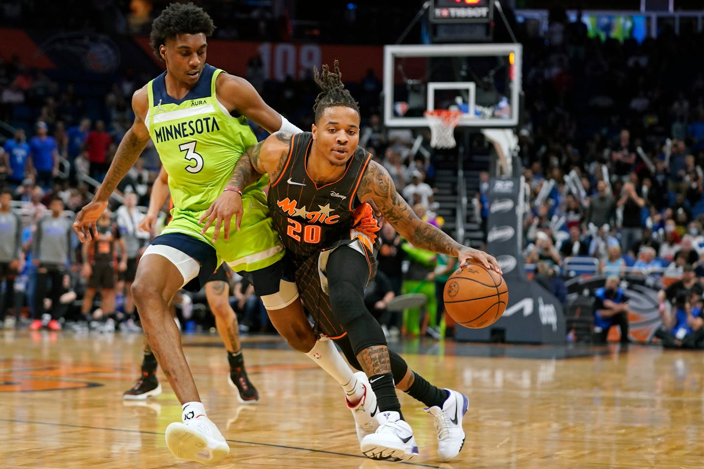 Orlando Magic guard Markelle Fultz (20) drives around Minnesota Timberwolves forward Jaden McDaniels (3) during the second half of an NBA basketball game, Friday, March 11, 2022, in Orlando, Fla. (AP Photo/John Raoux)