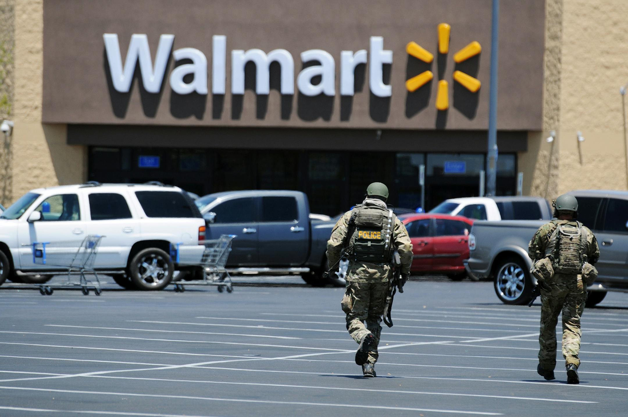 FILE - In this Sunday, June 8, 2014, file photo, Las Vegas police officers walk near the scene of a shooting in Las Vegas. At a time when shootings seem to happen almost daily, how should Americans react if someone opens fire at work, at school or at a theater or store? The Associated Press consulted experts on what to do. (AP Photo/Las Vegas Review-Journal, Eric Verduzco, File)