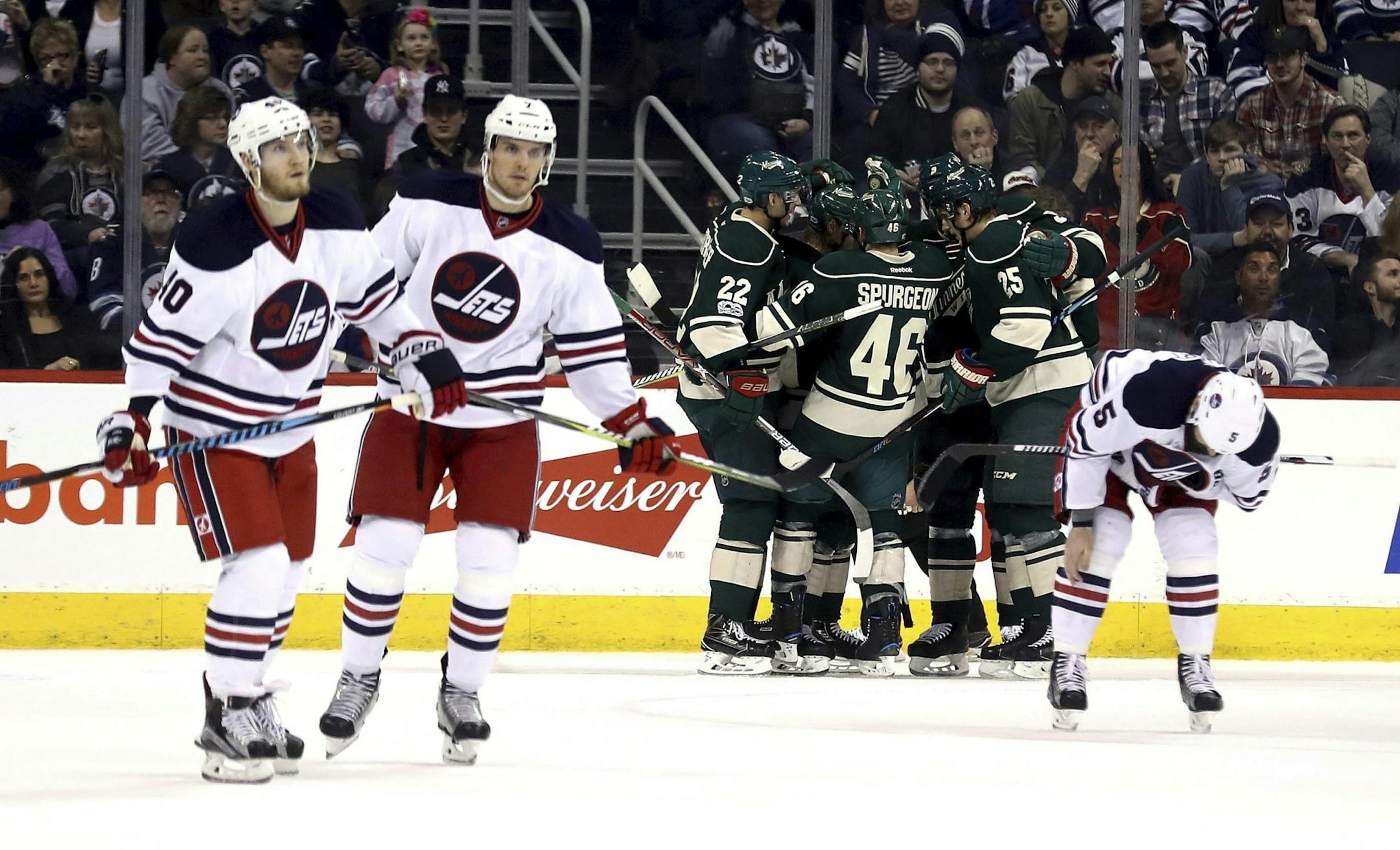 Minnesota Wild players celebrate after Mikael Granlund, obscured, scored against the Winnipeg Jets during the second period of an NHL hockey game in Winnipeg, Manitoba, Sunday, March 19, 2017.