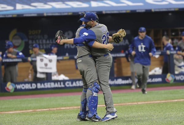 Israel's pitcher Josh Zeid, right, celebrates his team's victory with catcher Ryan Lavarnway against South Korea after the first round game of the Wor