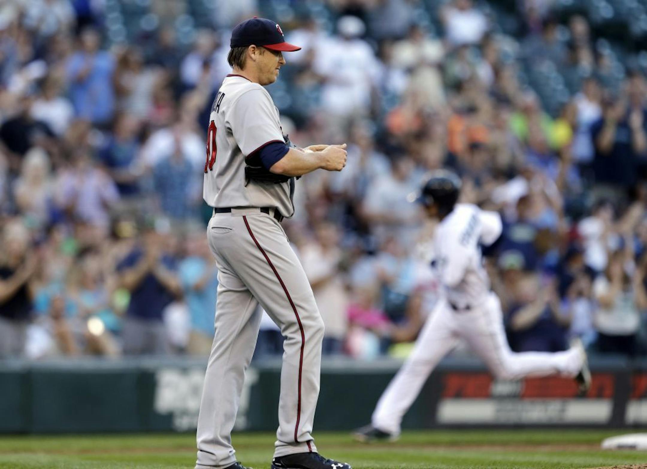 Minnesota Twins starting pitcher Kevin Correia waits as Seattle Mariners' Nick Franklin rounds the bases on a three-run home run in the second inning of a baseball game Thursday, July 25, 2013, in Seattle.