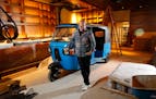 Chef Andrew Zimmern poses for a portrait with a tuk-tuk that will be part of decor inside his new restaurant Lucky Cricket.
