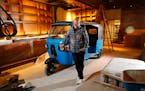 Chef Andrew Zimmern poses for a portrait with a tuk-tuk that will be part of decor inside his new restaurant Lucky Cricket.