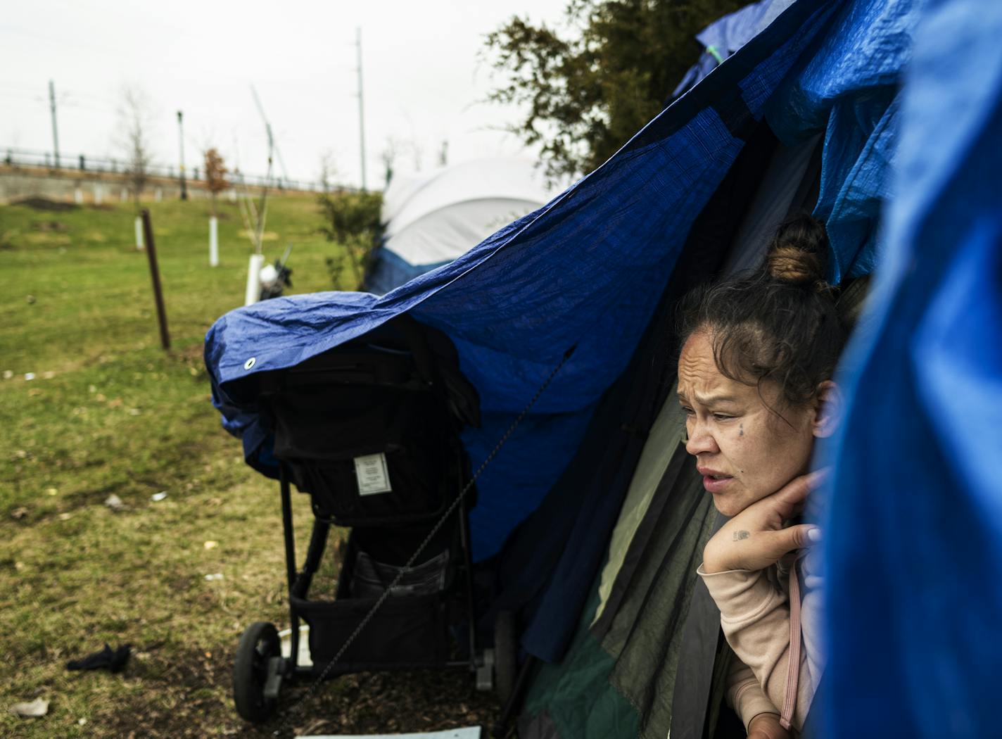 Jennifer Hernandez peeks out of her tent at "Camp Quarantine" as it has become informally known.